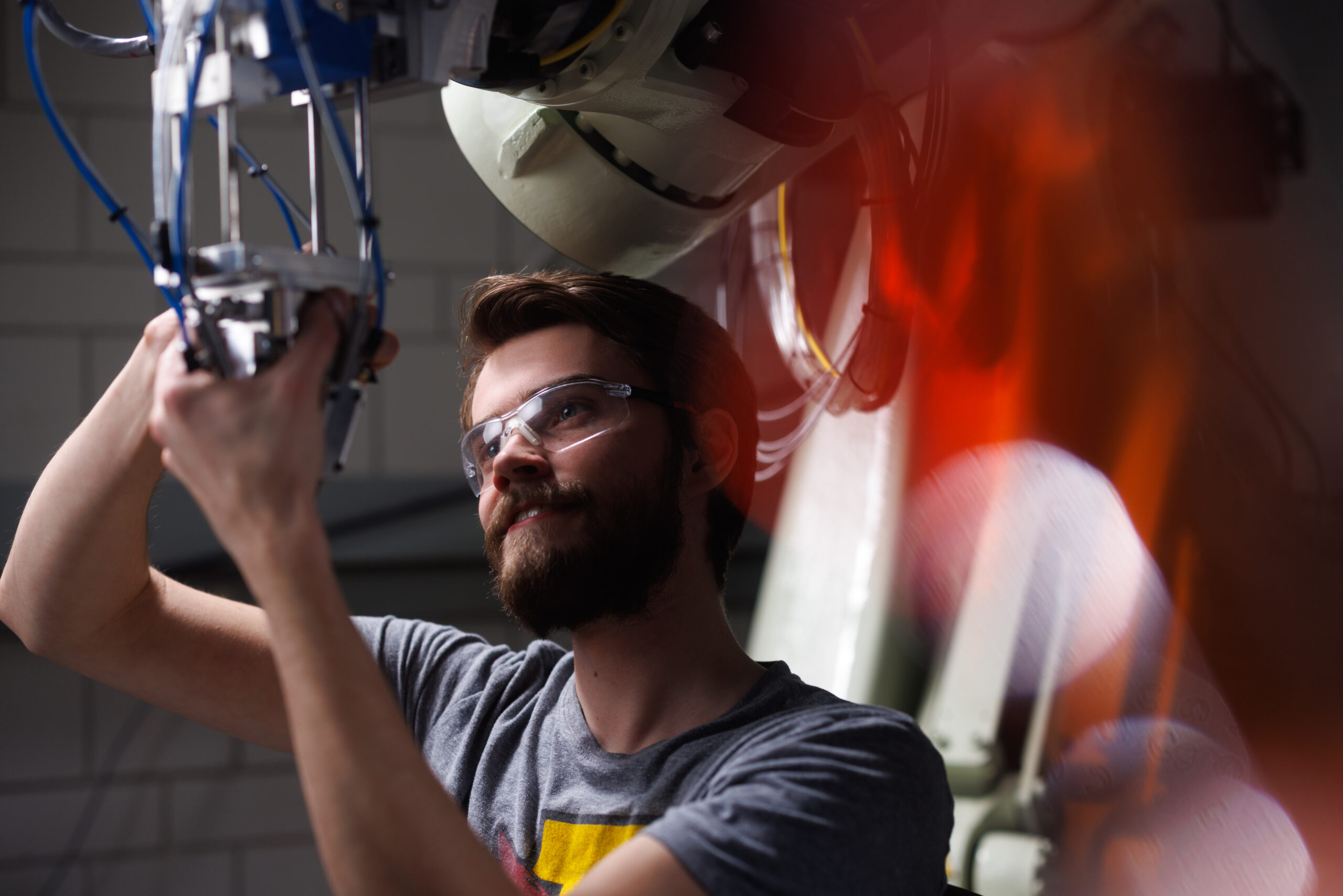 Walter Glockner works on robotic arm in laboratory.